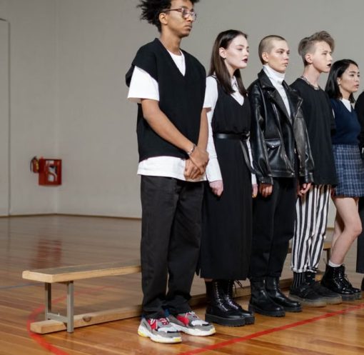 Diverse group of stylish teenagers standing in a gym, showcasing modern fashion trends.