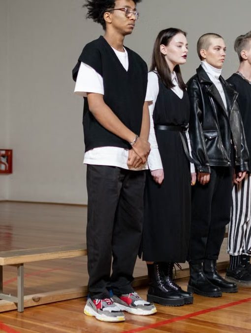 Diverse group of stylish teenagers standing in a gym, showcasing modern fashion trends.