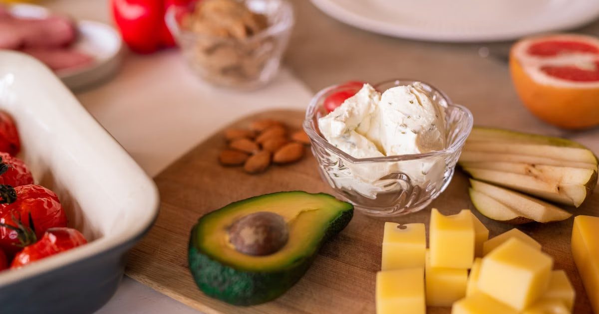 A vibrant platter of cheese, fruits, and vegetables on a wooden board, perfect for gatherings.