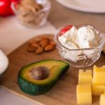 A vibrant platter of cheese, fruits, and vegetables on a wooden board, perfect for gatherings.