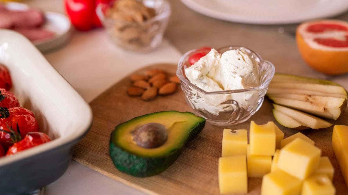 A vibrant platter of cheese, fruits, and vegetables on a wooden board, perfect for gatherings.
